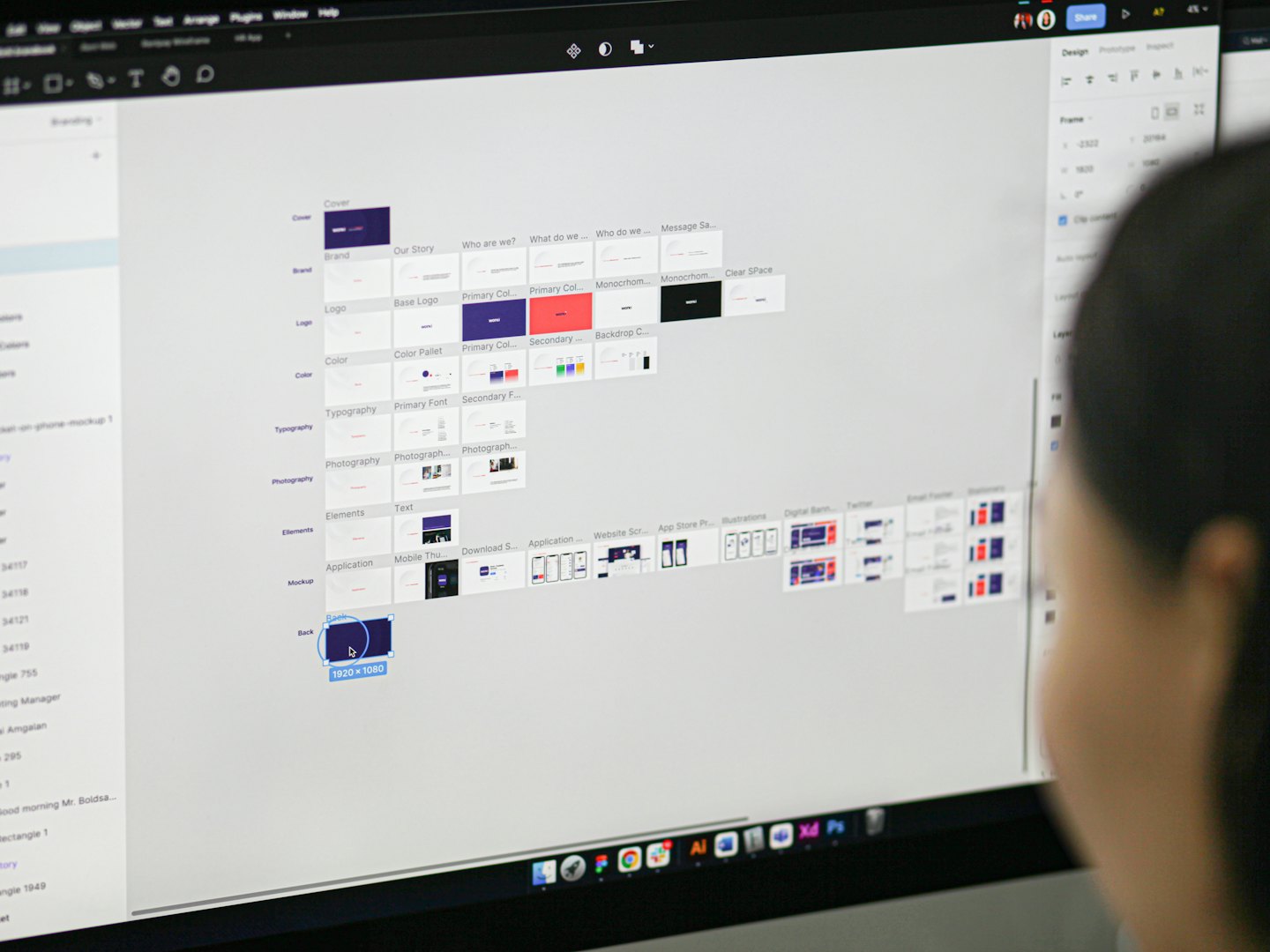 Designer che esamina componenti UI e design system su schermo di computer.