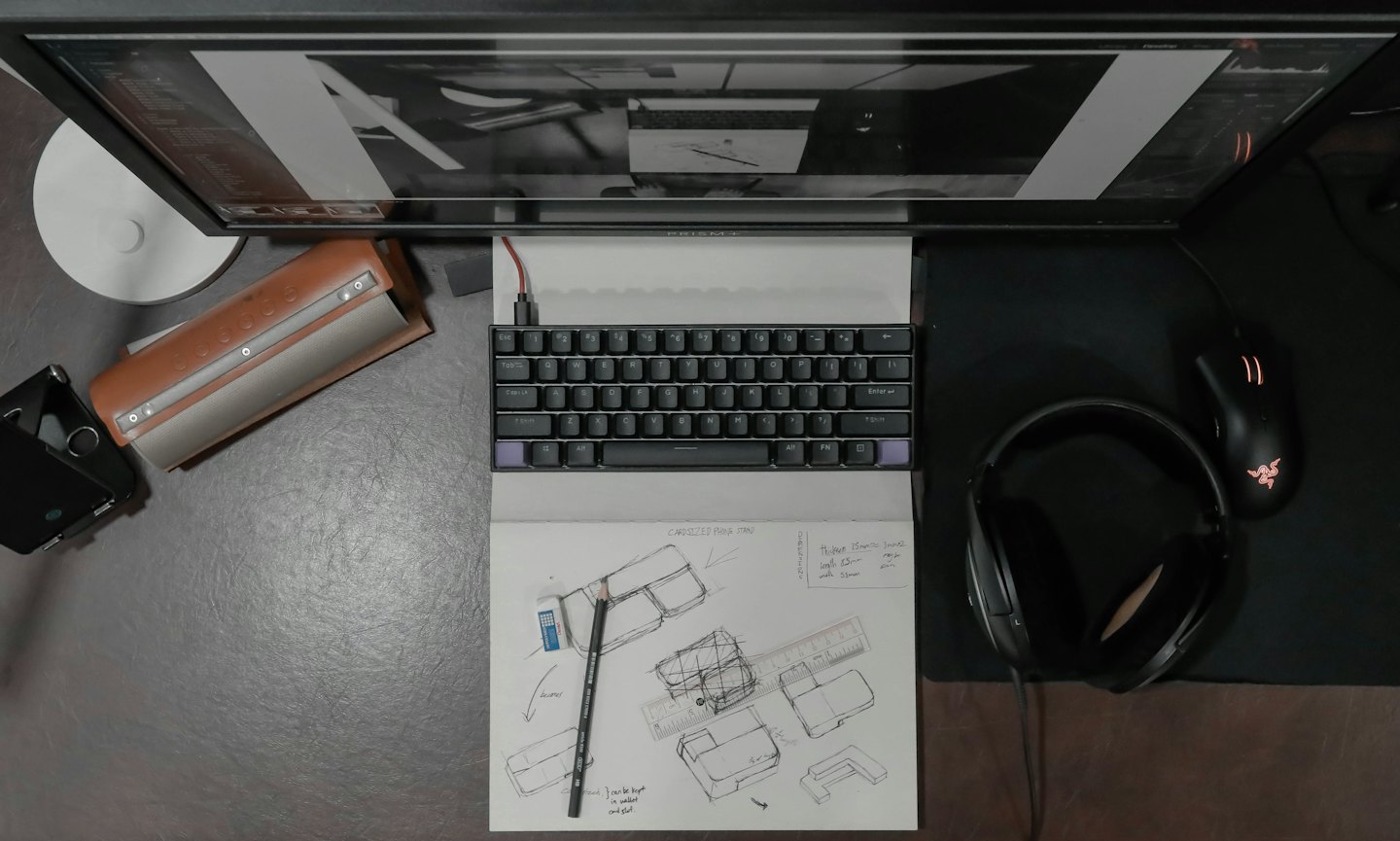 Scrivania di design moderna con tastiera e schizzi dettagliati di prodotti.